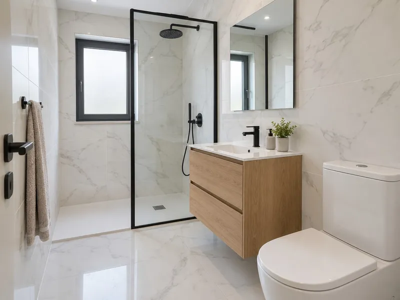 Casa de banho remodelada com azulejo efeito mármore e resguardo de duche preto
