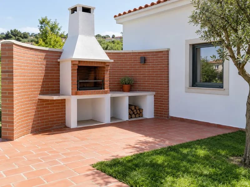 Churrasqueira e anexo em tijolo construídos junto a uma casa